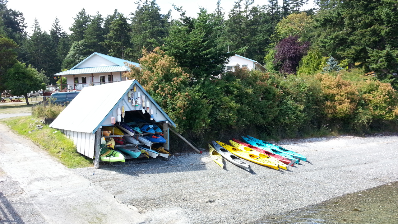 Center Island Community boathouse on the beach with colorful kayaks stored inside