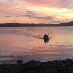 A kayaker coming in to shore during sunset